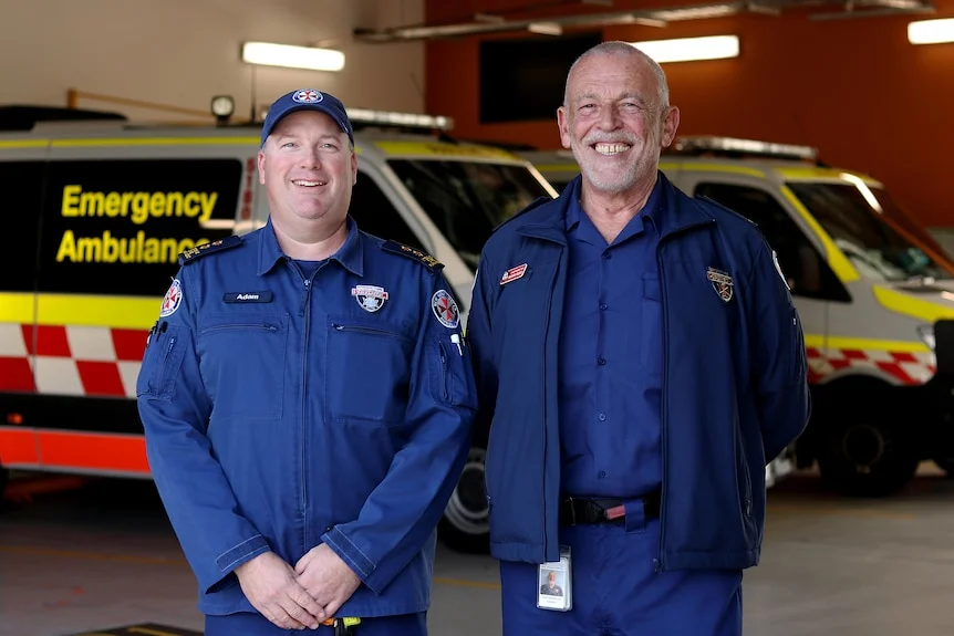 Two paramedics standing in front of ambulance