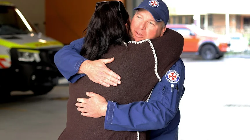 Paramedic hugging woman 