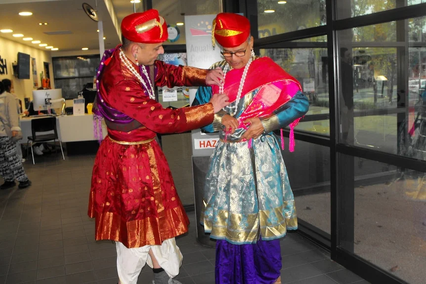 Rishikesh and Madan, wear elaborate and colourful Indian clothes, turban, Madan helps Ris