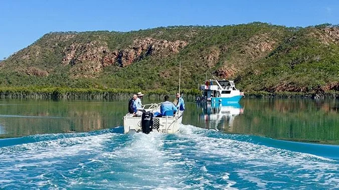 boats on Kimberley river with red cliffs 