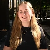 Woman with blonde brown hair, black top, headshot