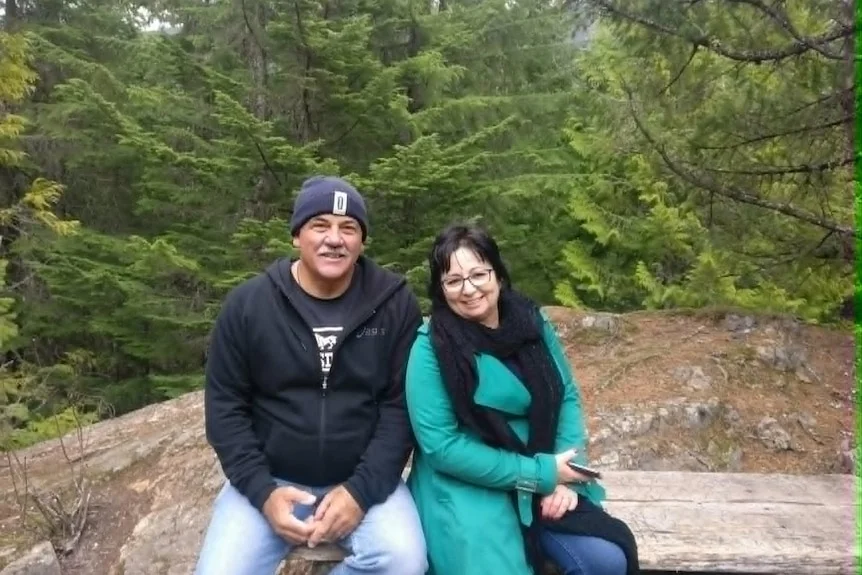 Man and woman in forest smiling at camera, on holidays, winter time
