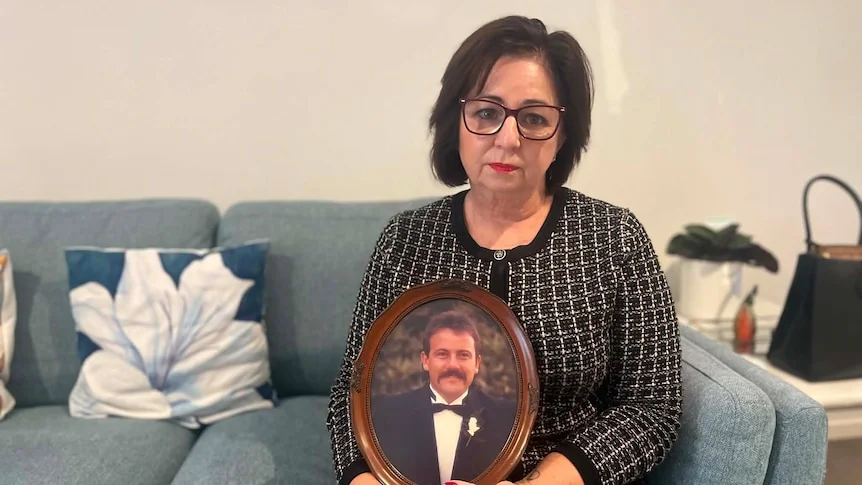 Woman looking at camera, make up on, framed old photo of groom