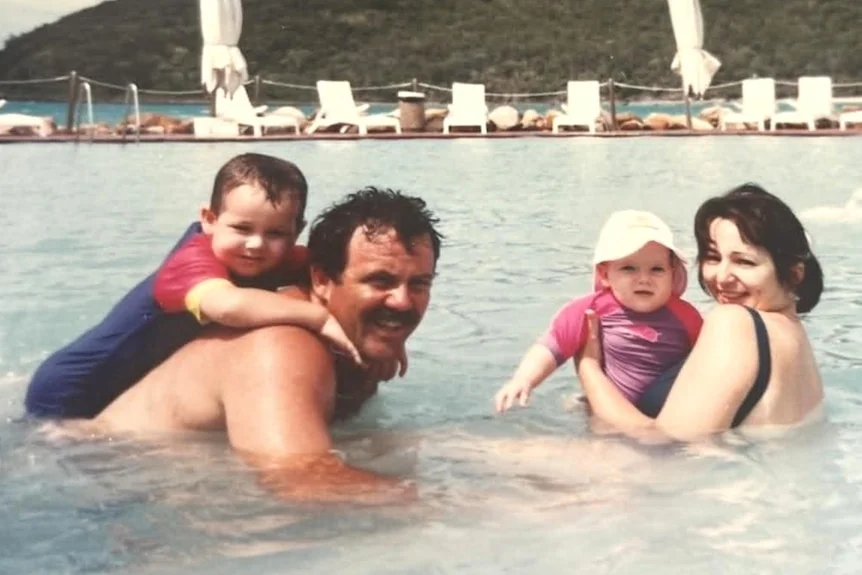 Mum and dad with young kids in pool