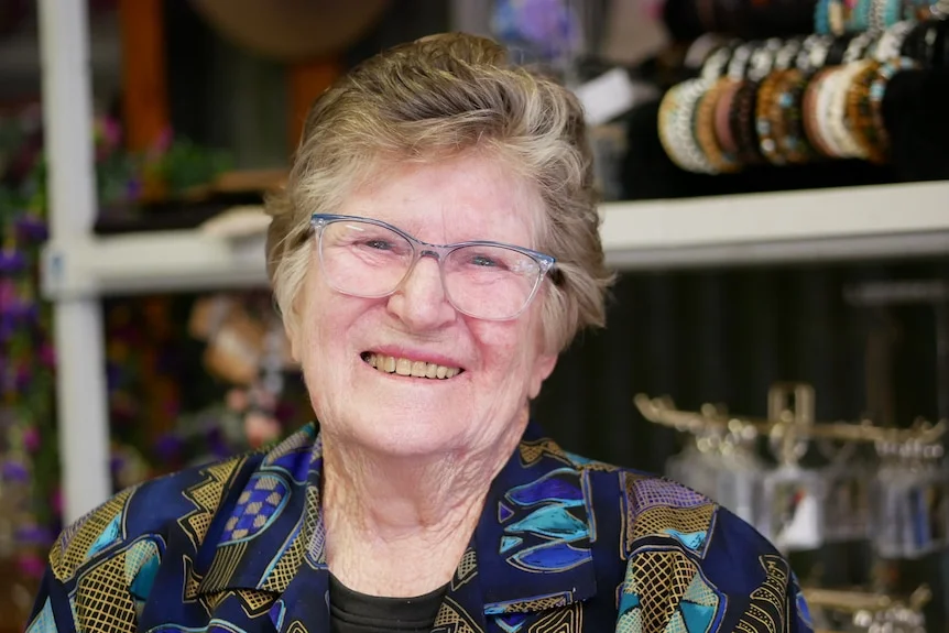 Mary in a blue and green shirt, smiling at the camera