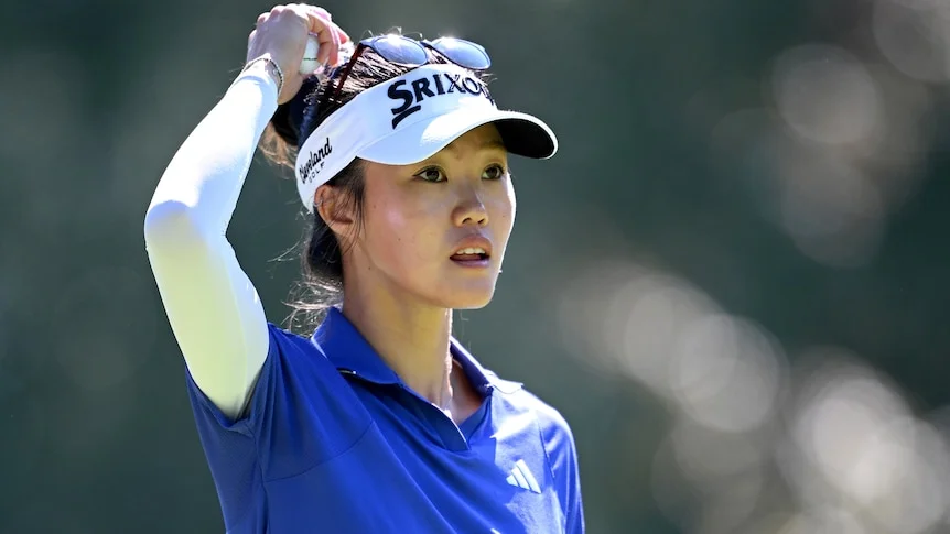 Grace Kim scratches her head with her right hand
