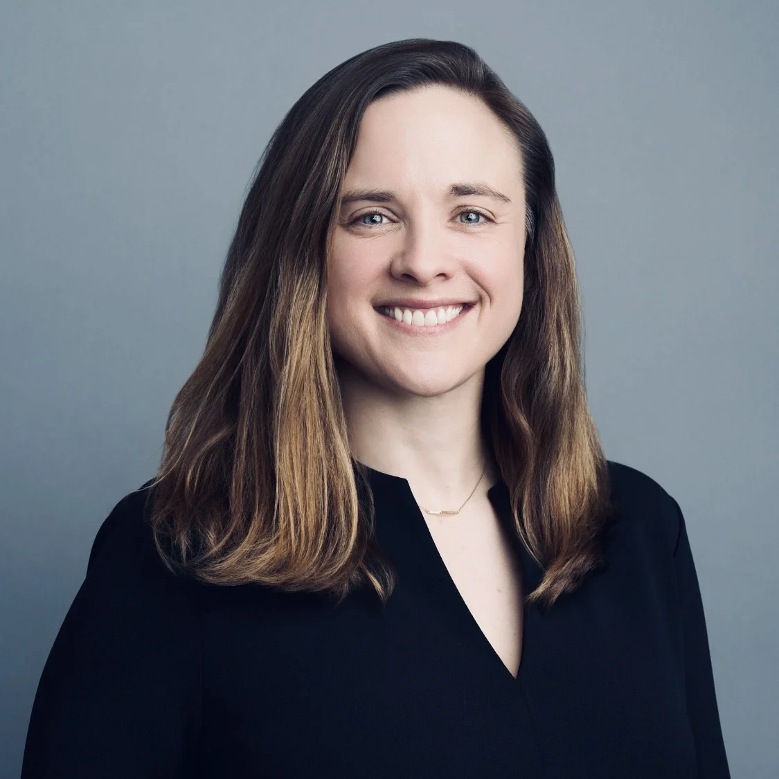 photo of a smiling woman with shoulder length, light brown hair
