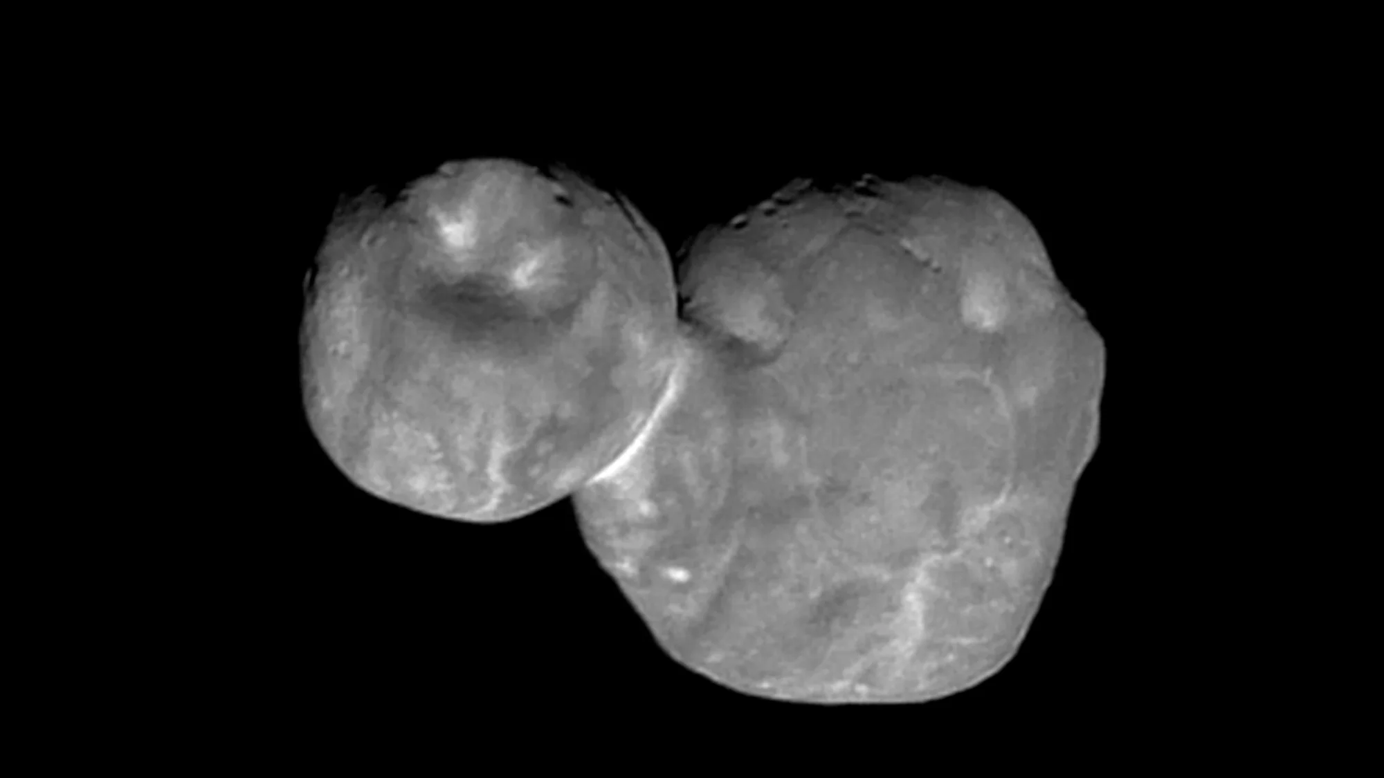 two lumpy space rocks joined together to form a roughly snowman-like shape, on a black background