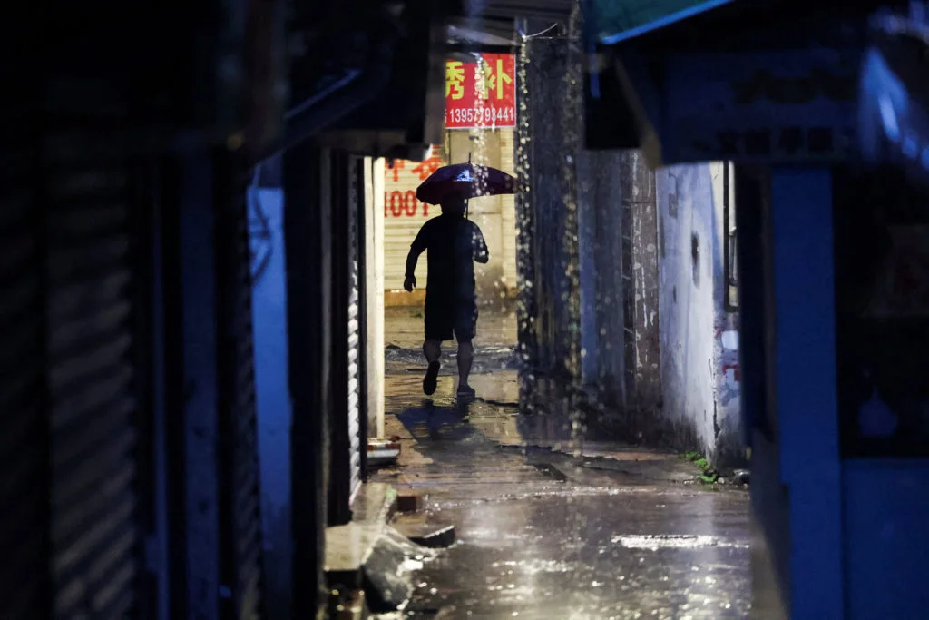 A person walks with an umbrella as Typhoon Bavi approches in Wenzhou