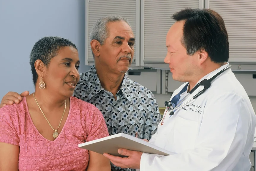 Medical consultation between a male doctor and two patients. 