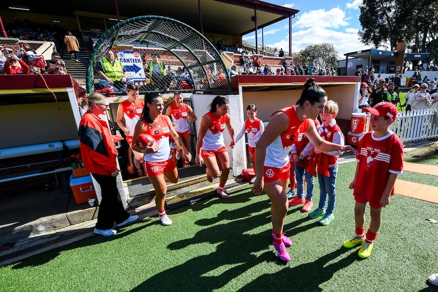 Lucy McEvoy of the Swans leads her team out during the round one AFLW match.