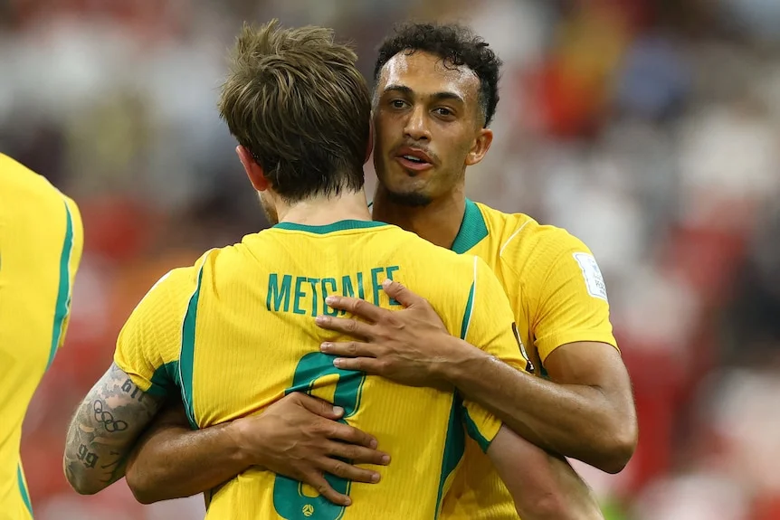 Connor Metcalfe and Nishan Velupillay hug on the pitch.