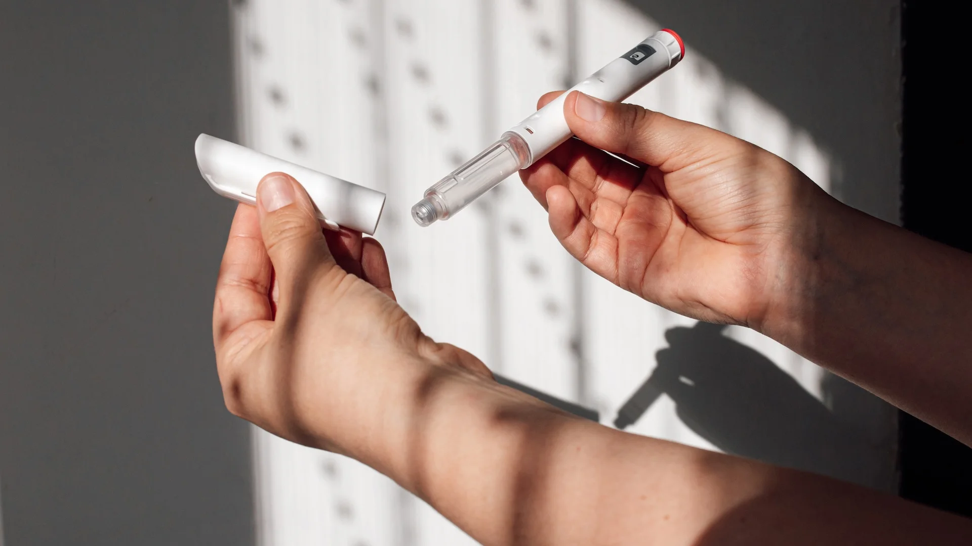 a person holds a GLP-1 injector