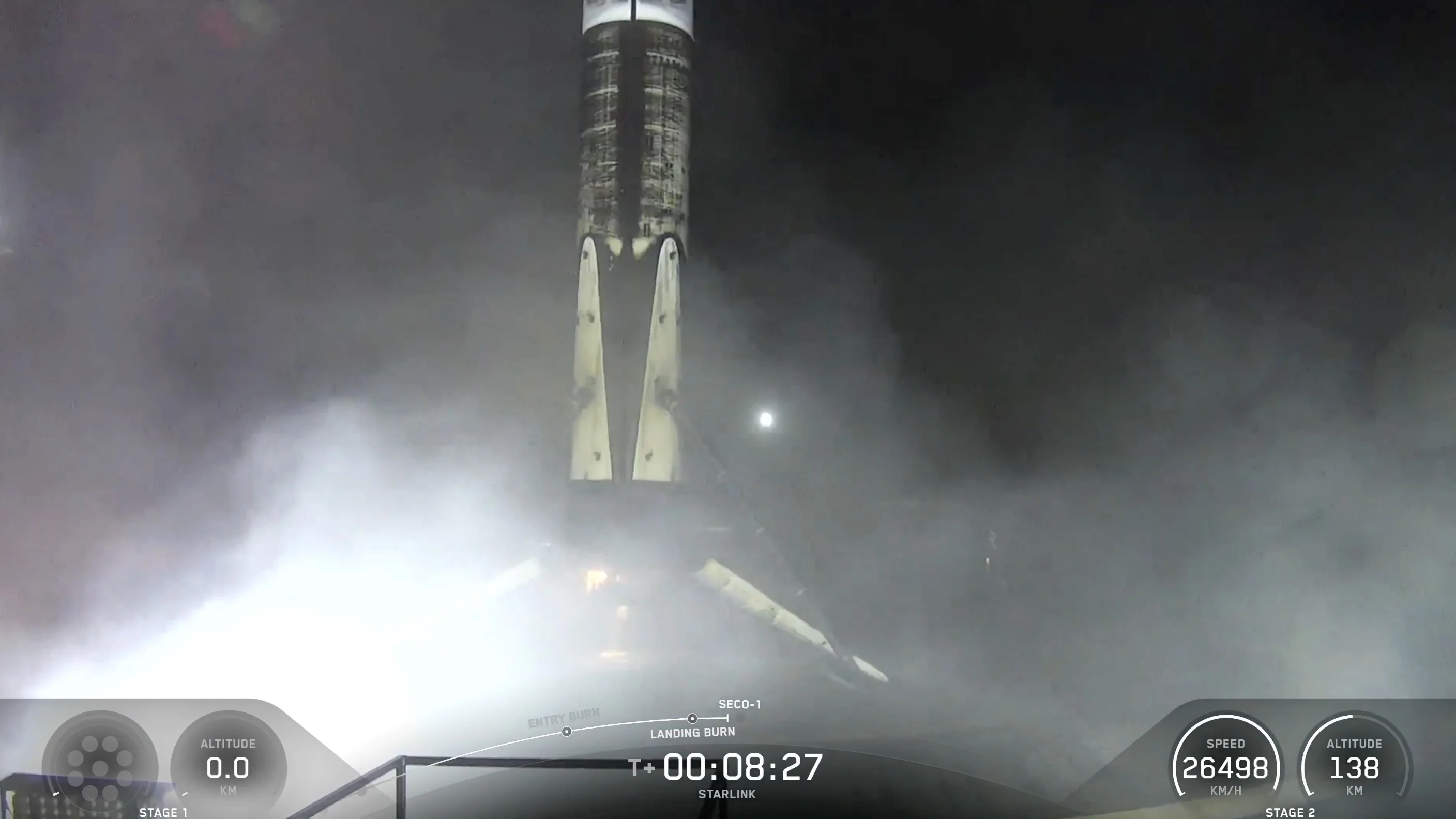 A black and white spacex falcon 9 rocket first stage sits on the deck of a ship at sea.