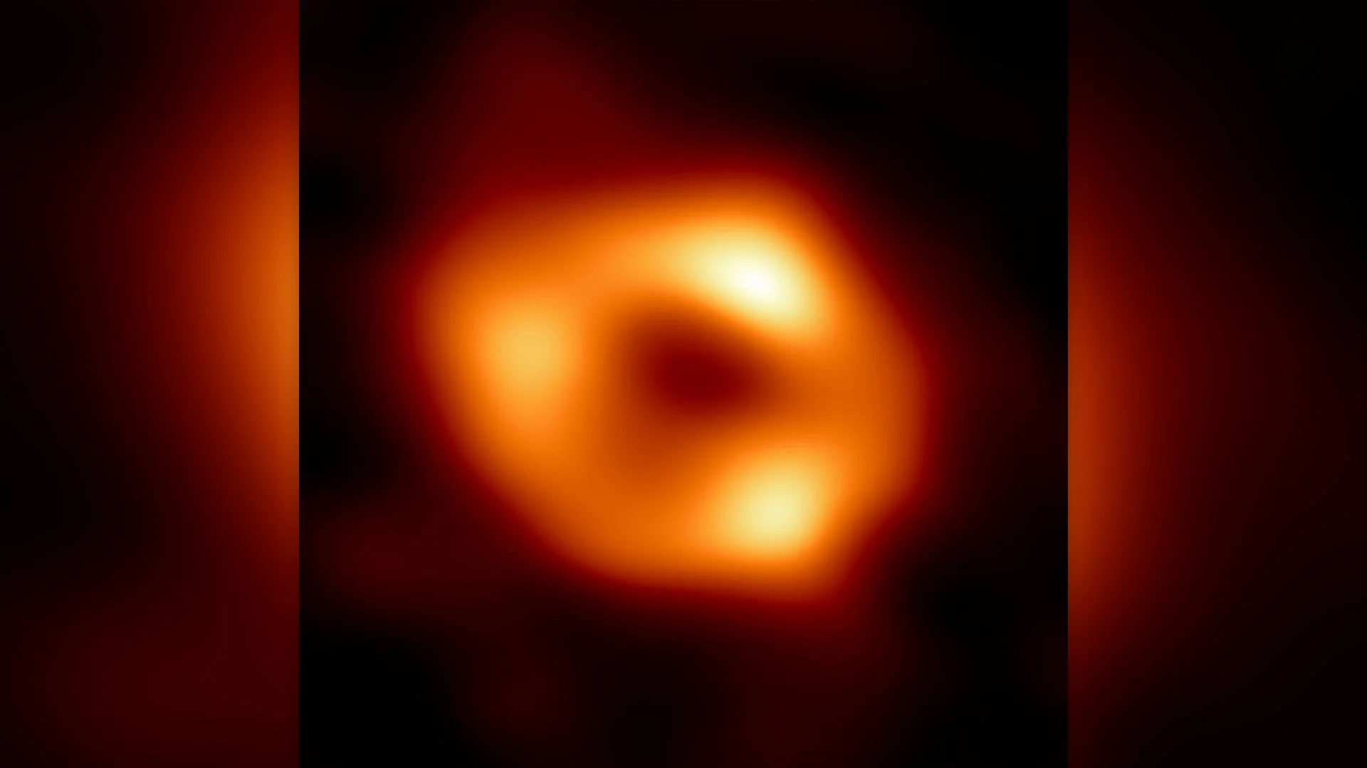 A blobby orange, fuzzy sphere against a dark background.
