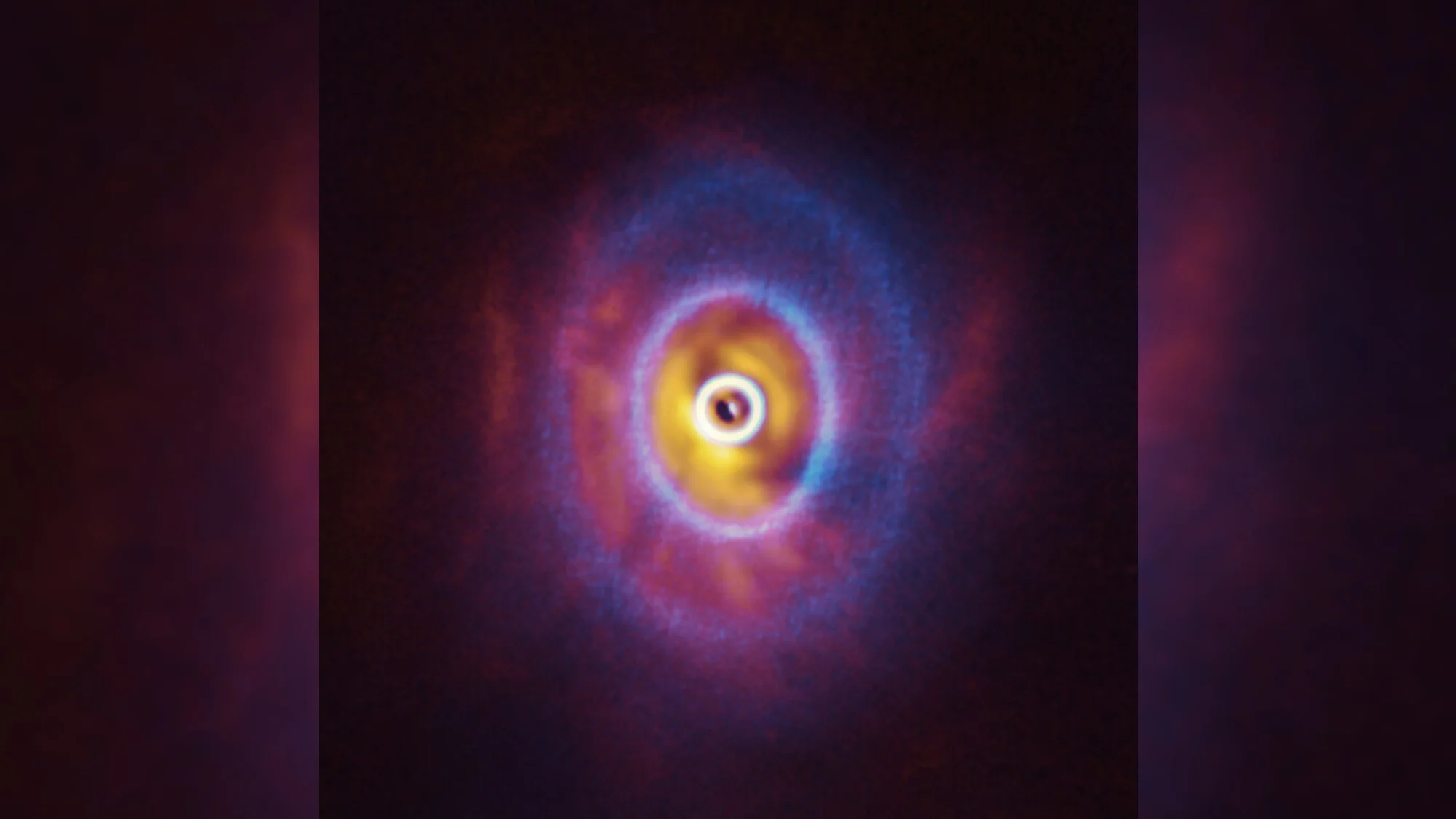 three bright concentric rings of cloudy light on a black background