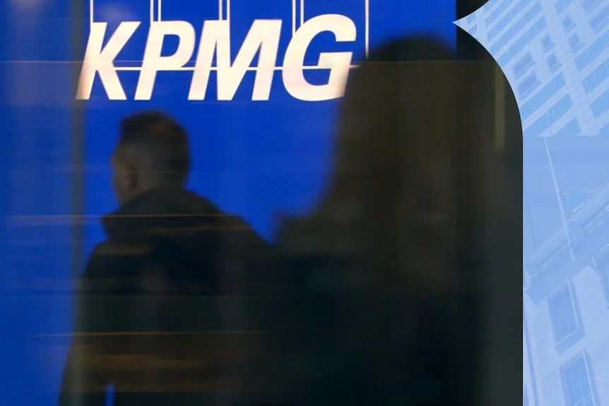 KPMG logo with two people in front of it, unidentifiable