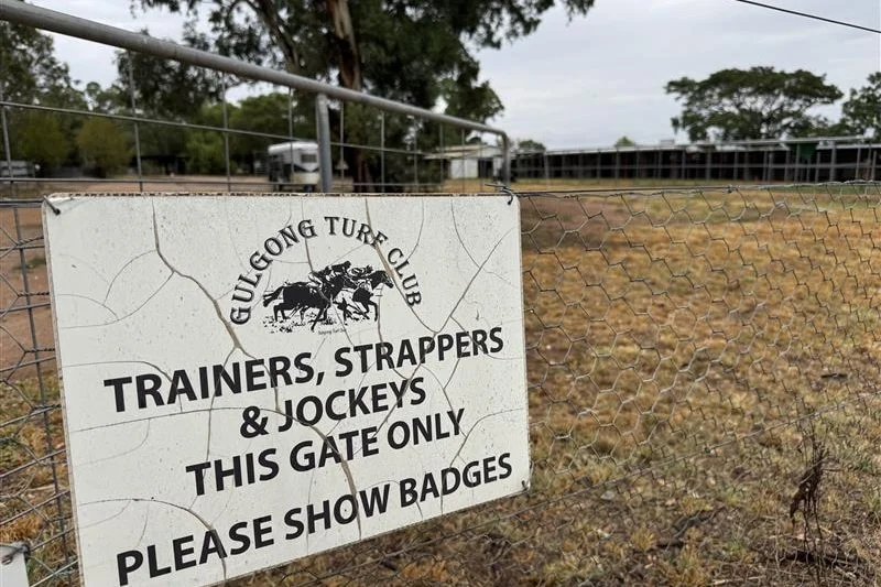 A sign on a gate on a country property.