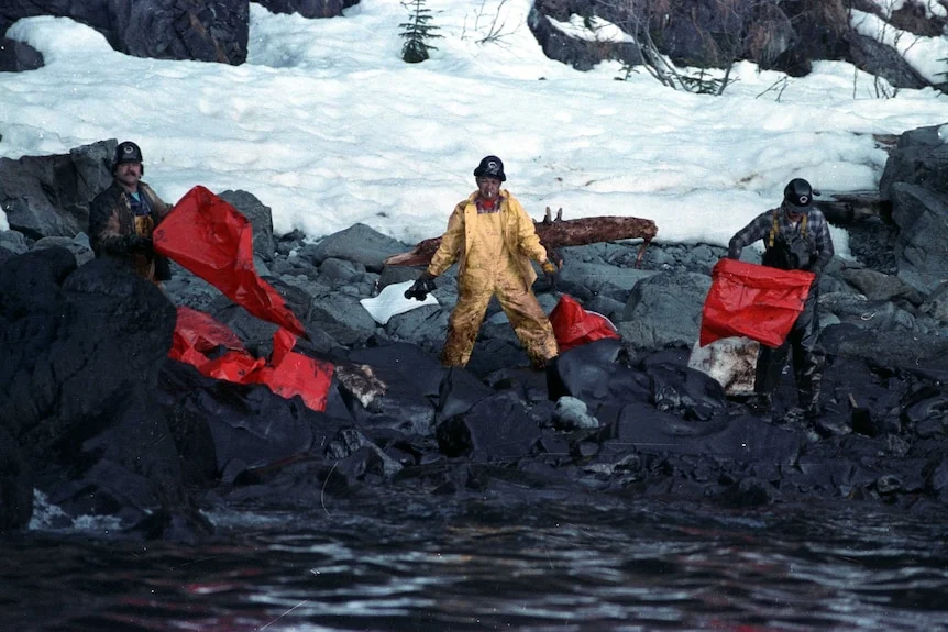 Workers covered in oil as they attempt to clean the Exxon Valdez oil spill
