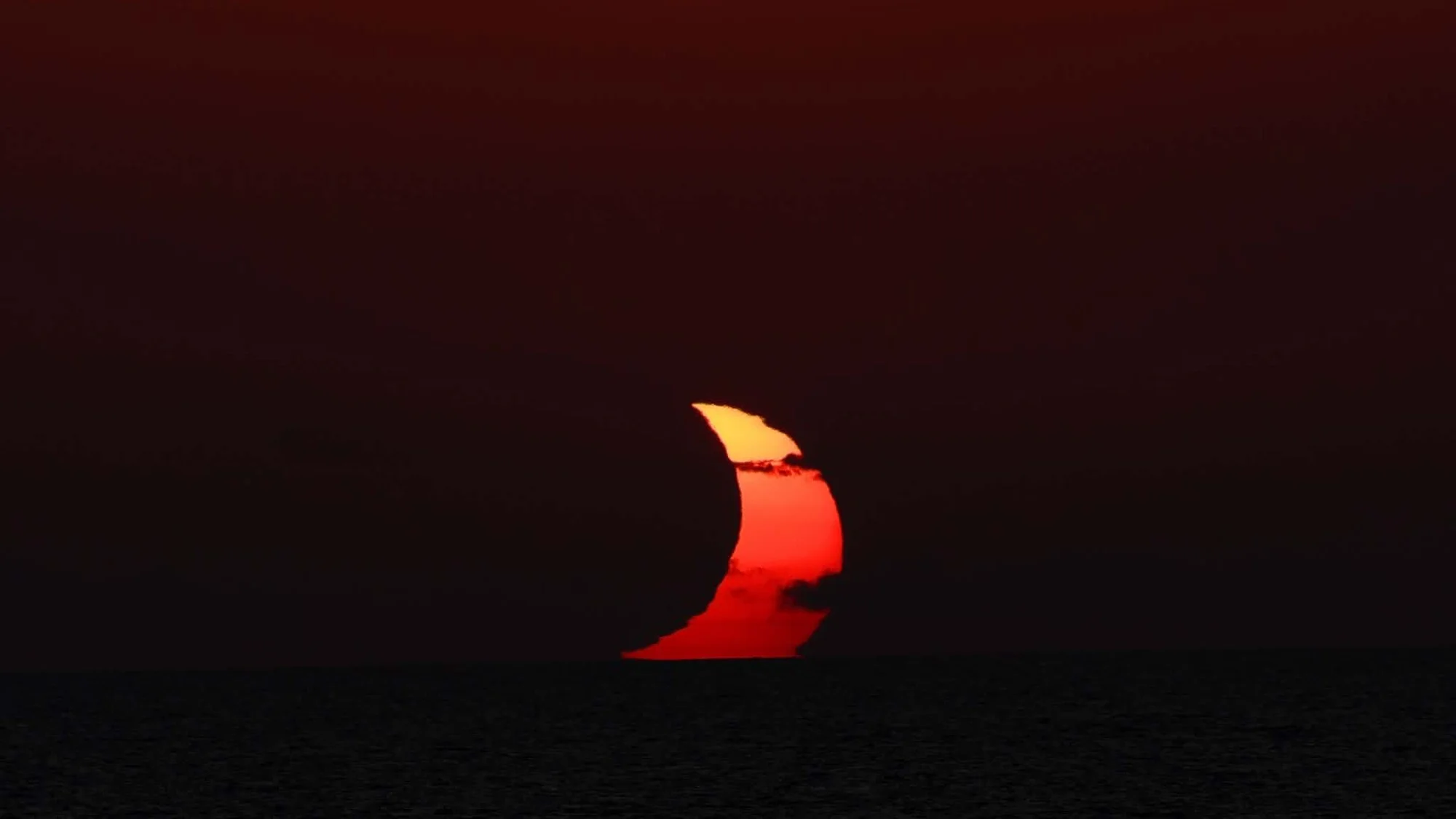 people sit on the deck of a ship wearing paper sunglasses, looking skyward