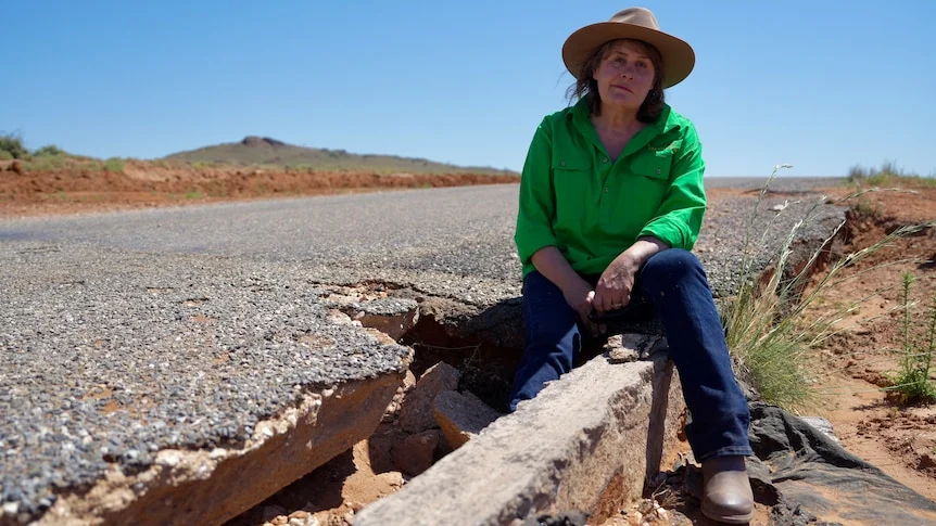 Sam Maiden of Mt Gipps Station sits in a large pothole on the road