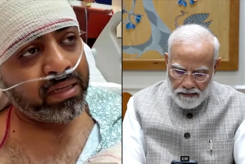 A man covered in bandages and a breathing tube speaks to an elder statesman.