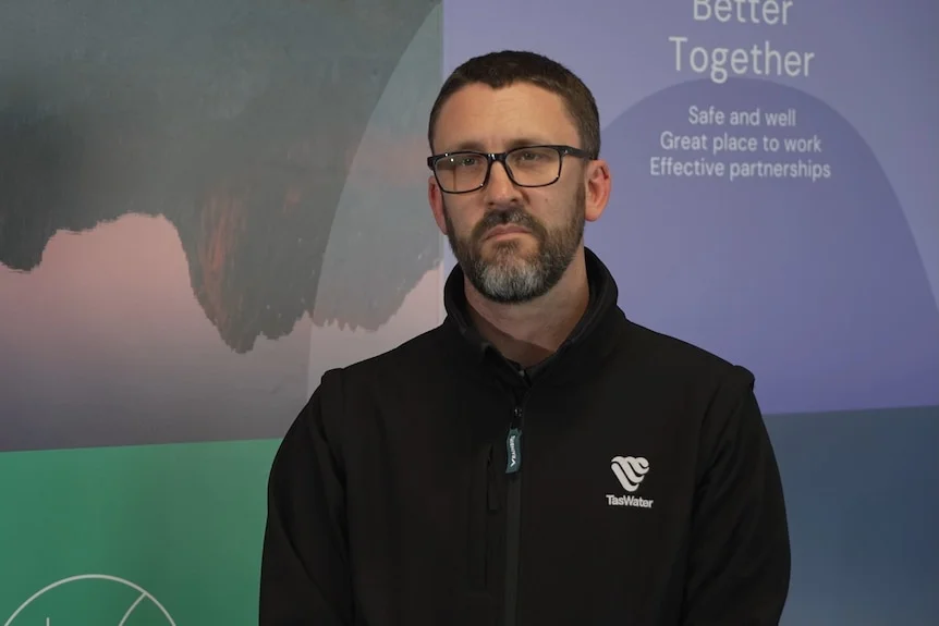 A man stands in front of a wall which reads "better together"