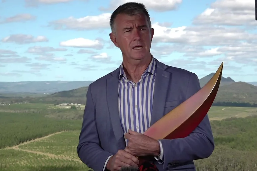 Olympics Minister Tim Mander holding a piece of the Brisbane 2032 emblem.