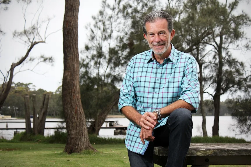 Richard Morecroft sits on a park bench at St George's Basin.