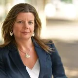 Jane Bardon in a blazer looking at the camera.