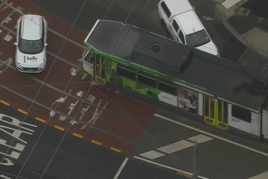 Two white cars appear to be blocking a tram in South Melbourne