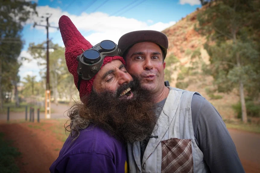 Costa and scrapboy, dressed in colourful outfits and pulling funny faces, pose for the camera.