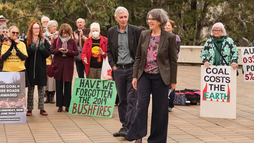 A small group of people with anti-coal mine placards