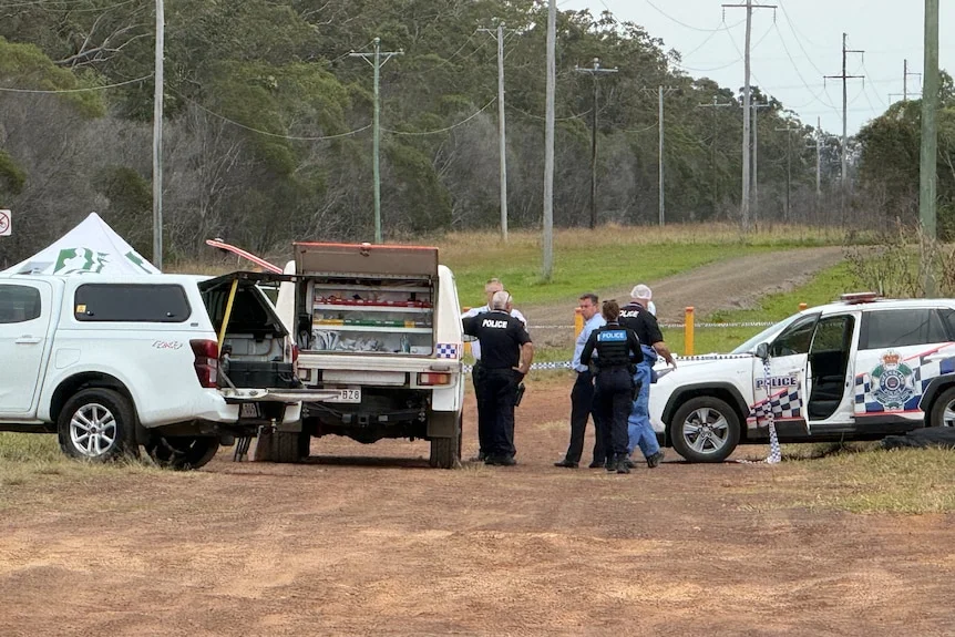 A group of police officers and forensic experts comb a crime scene for potential clues.