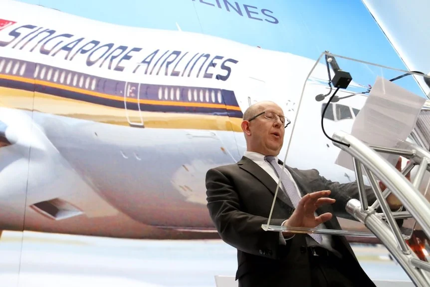 Stephen Byron stands in from of a Singapore Airlines backdrop.