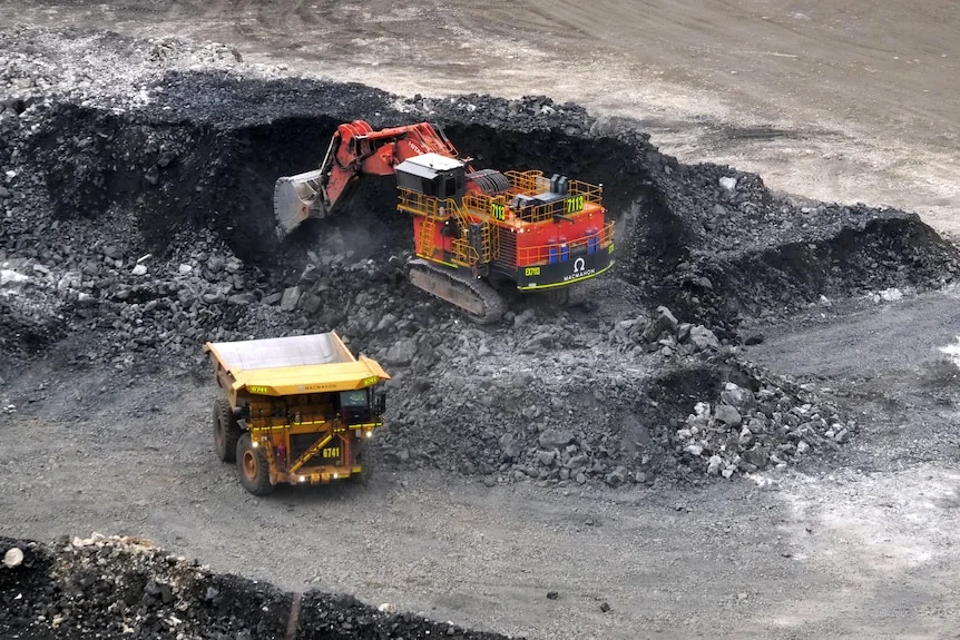 A mine excavator digs out a pile of lithium ore.