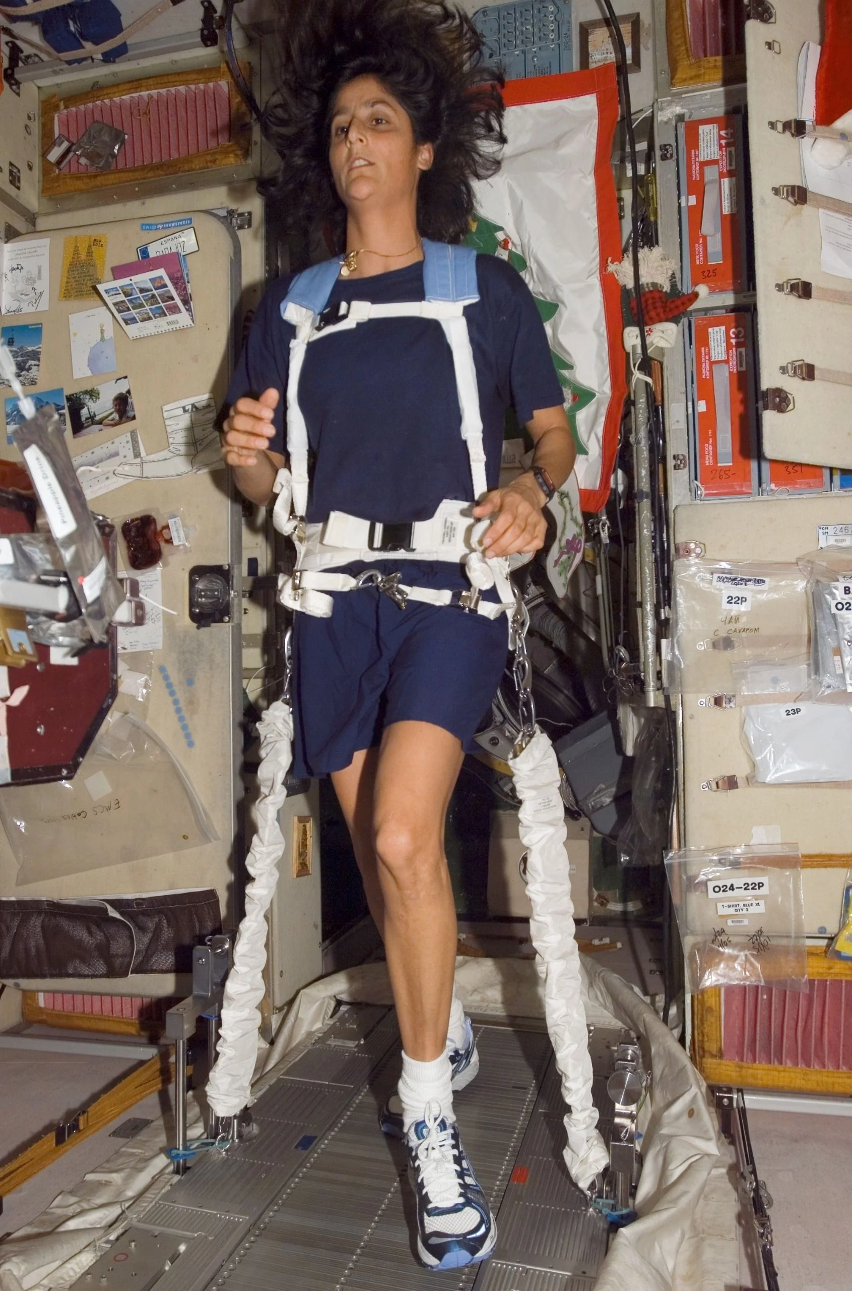 A woman walks on a treadmill in space.