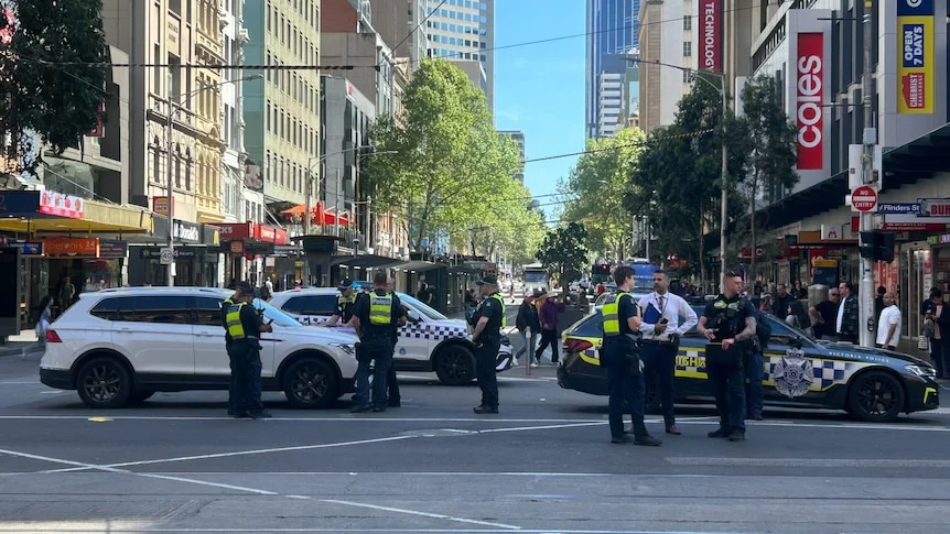 multiple police and vehicles at the intersection of Elizabeth and Flinders streets 