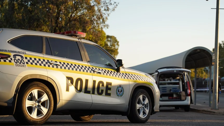 An SA Police vehicle parked in front of a van with back door opened