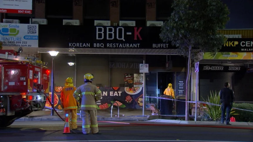 Firefighters standing outside the restaurant called BBQ-K.