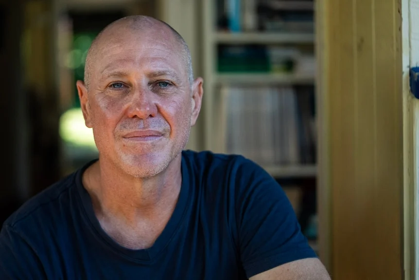 A portrait shot of a man in a blue shirt.